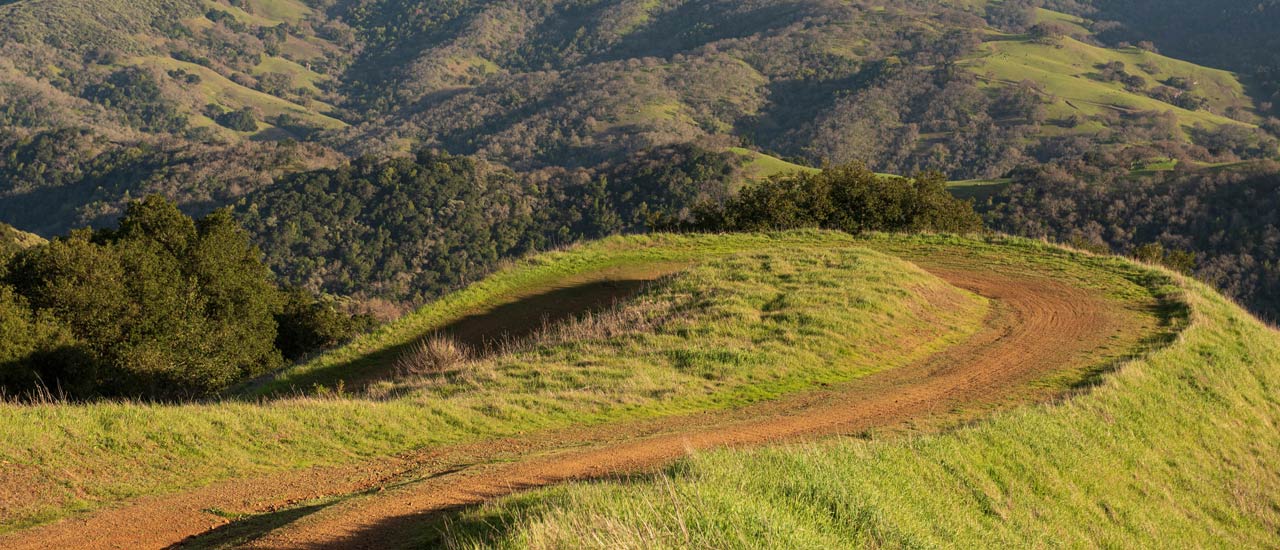 A wide trail winds around the hillside.